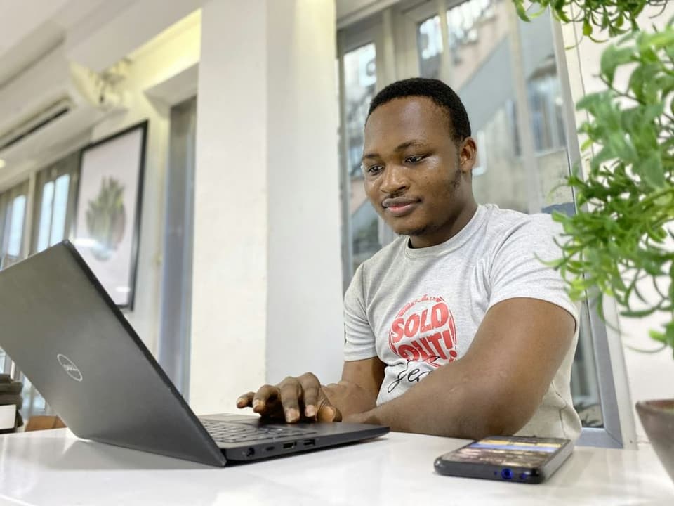 Un homme concentré travaille sur son ordinateur portable dans un bureau lumineux