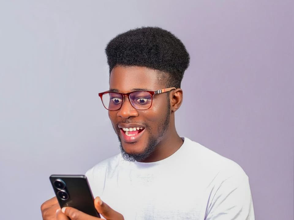Un homme souriant découvre un message sur son téléphone